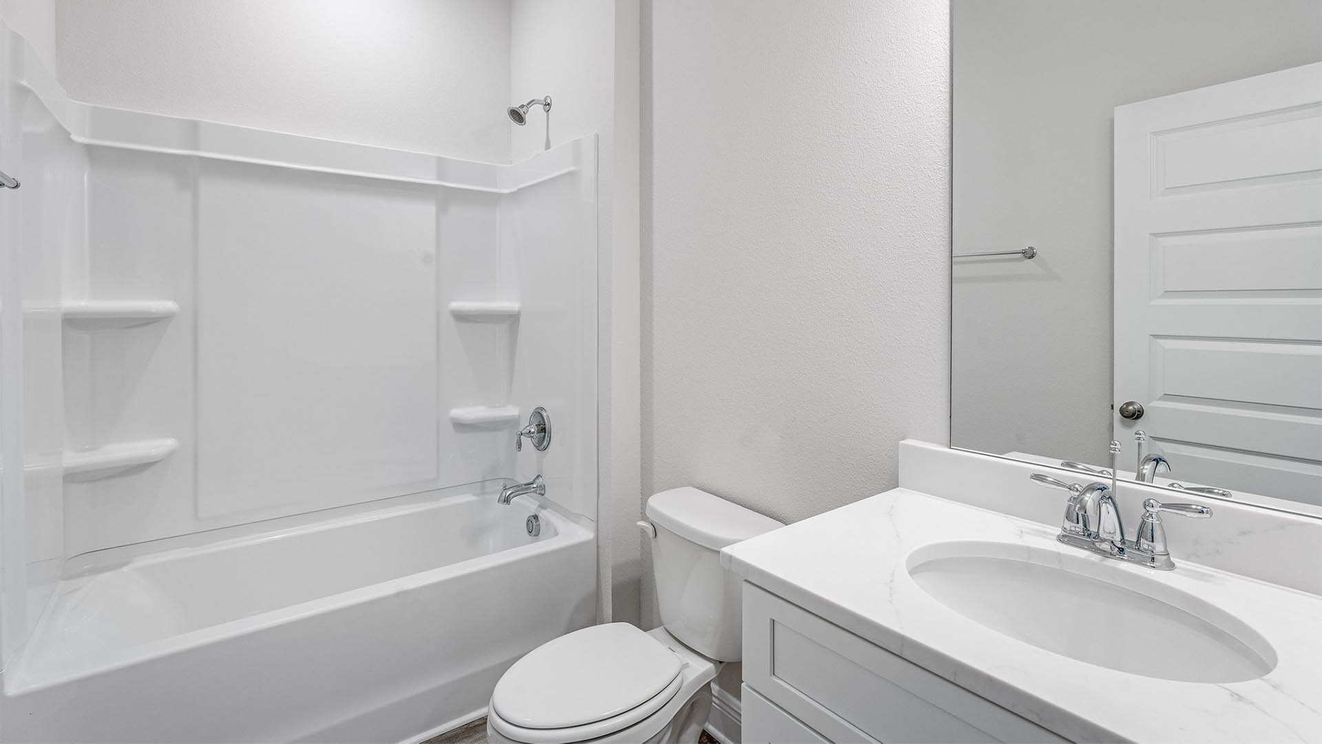Bathroom with white cabinets and shower and quartz countertops.