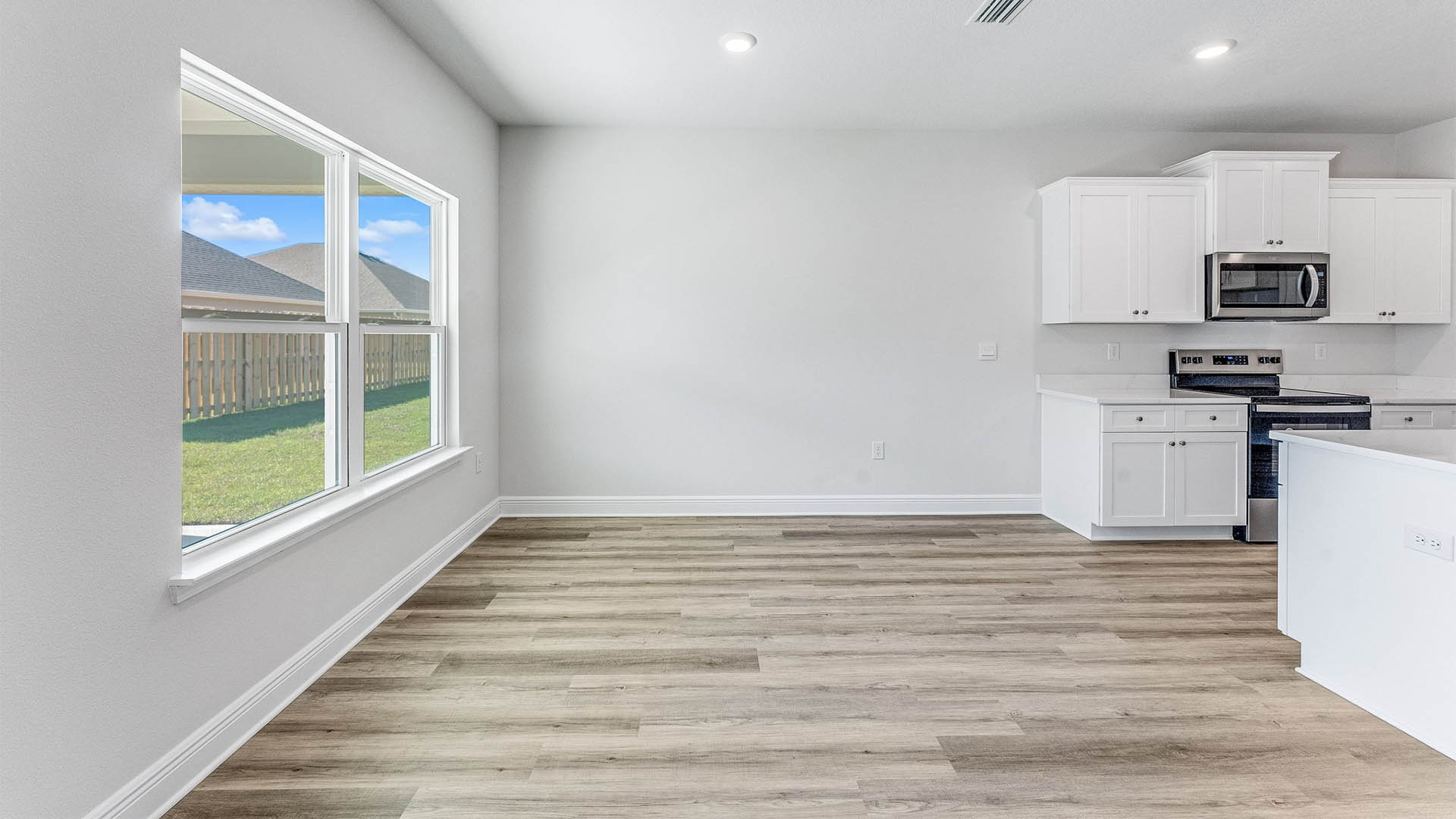 Dining area next to kitchen with EVP floors and windows.
