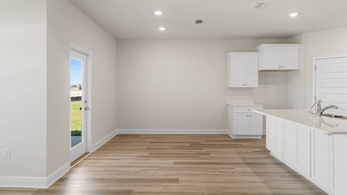 Dining area with EVP flooring next to back door.