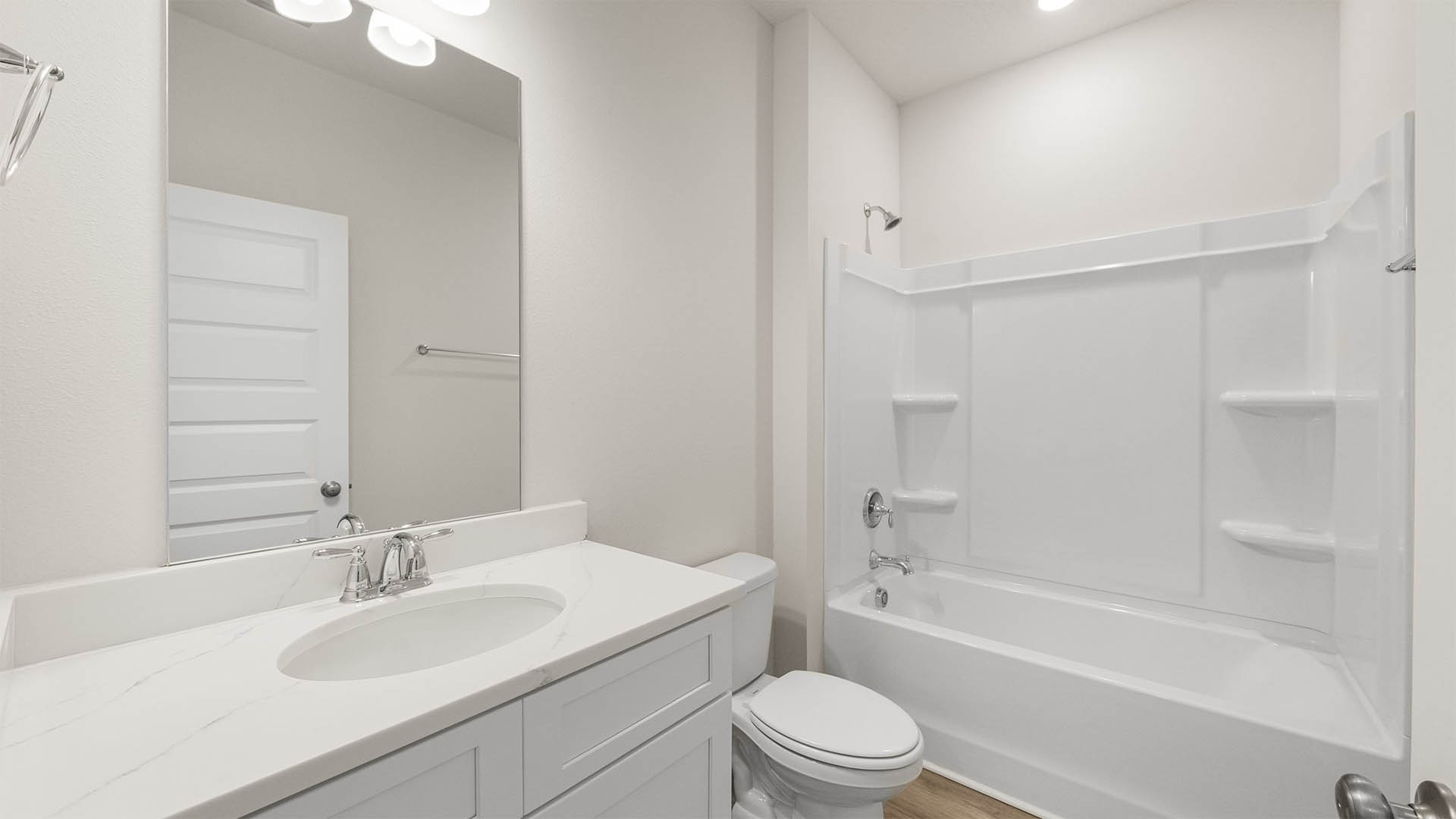 Bathroom with single vanity quartz countertops and toilet and shower and tub combo with EVP flooring.