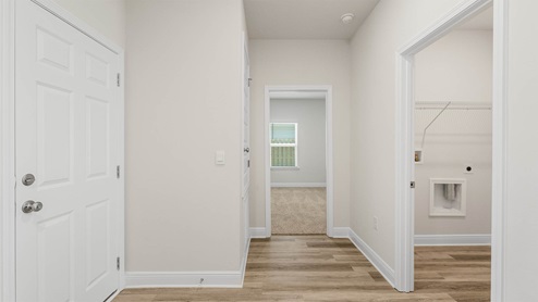 Hallway next to laundry room and bedroom and garage.