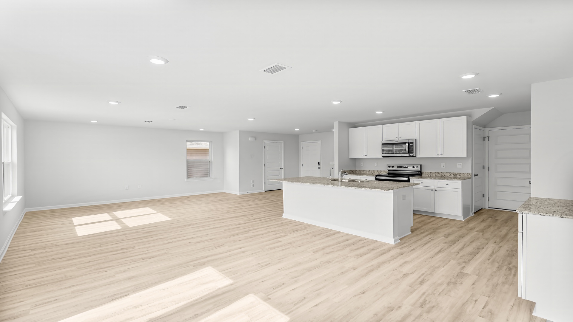 Open living room with EVP flooring and kitchen and dining area.