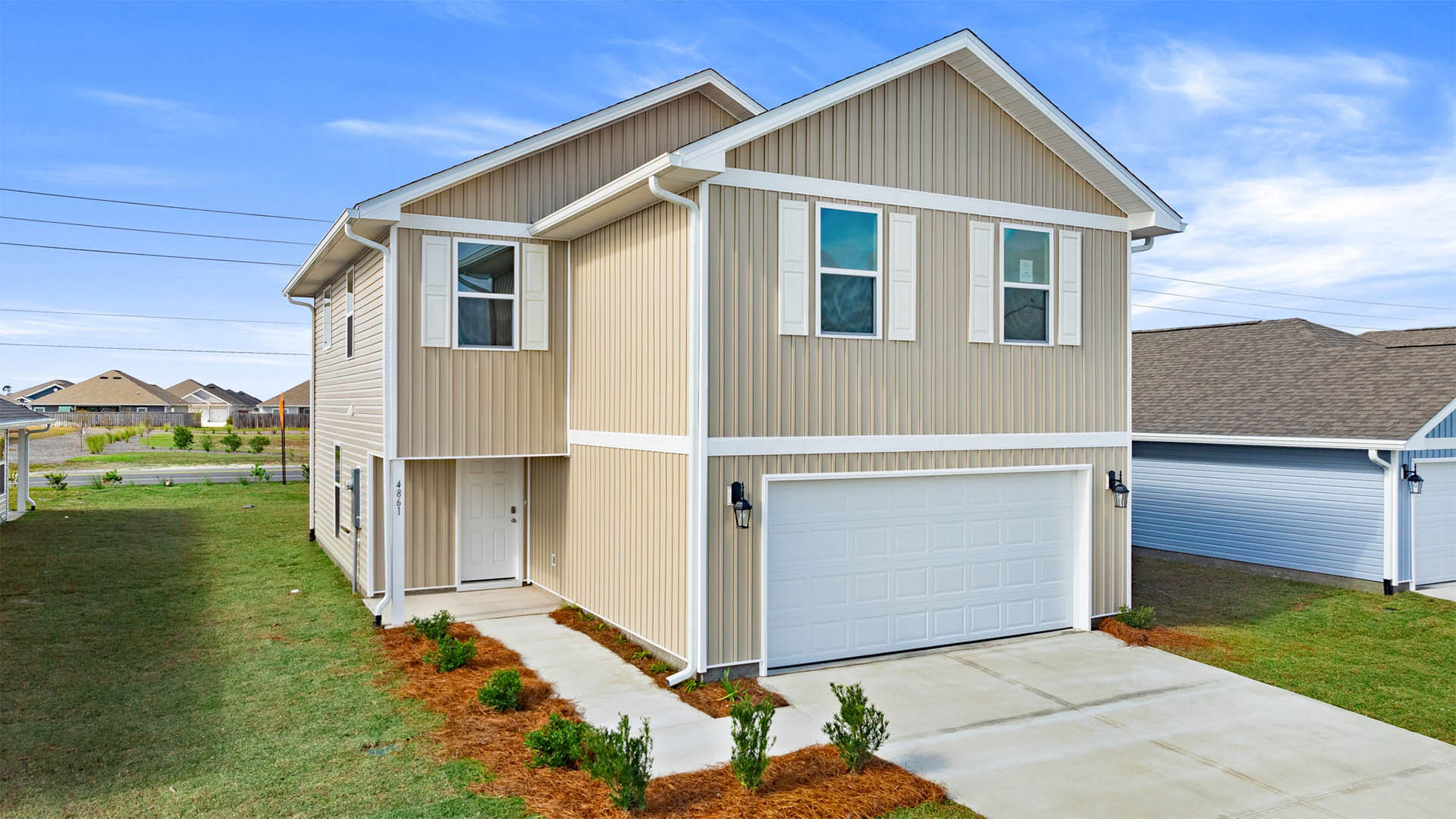 Aisle plan front of home with vinyl siding and two-car garage.