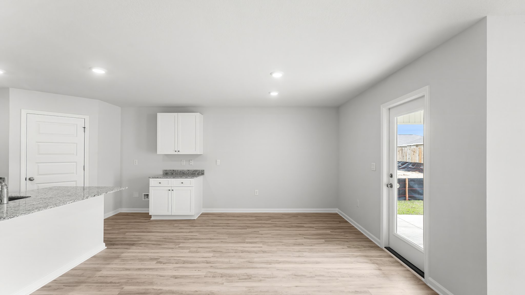 Dining area with EVP flooring and back door next to kitchen.