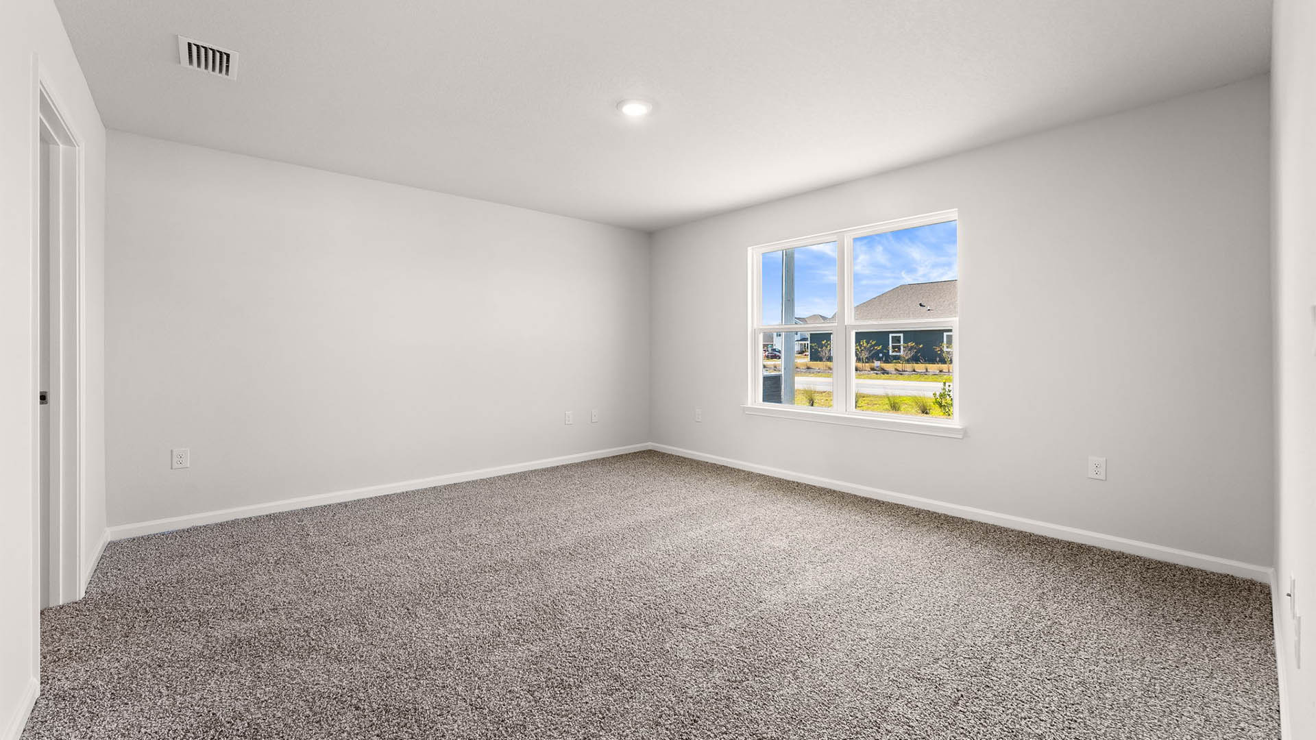 Primary bedroom with carpet floors and windows.