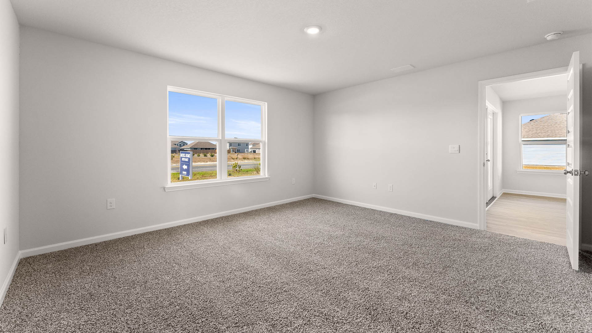 Primary bedroom with carpet floors and living room entrance.