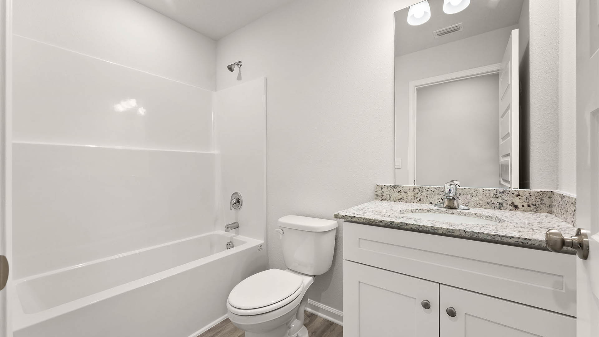 Bathroom with single vanity granite countertops and shower and tub combo and toilet.