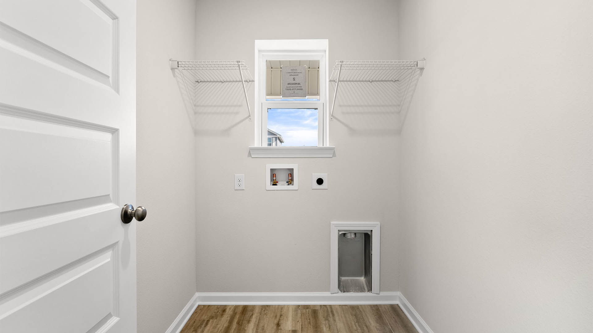 Laundry room with EVP flooring and window and ventilated shelving.