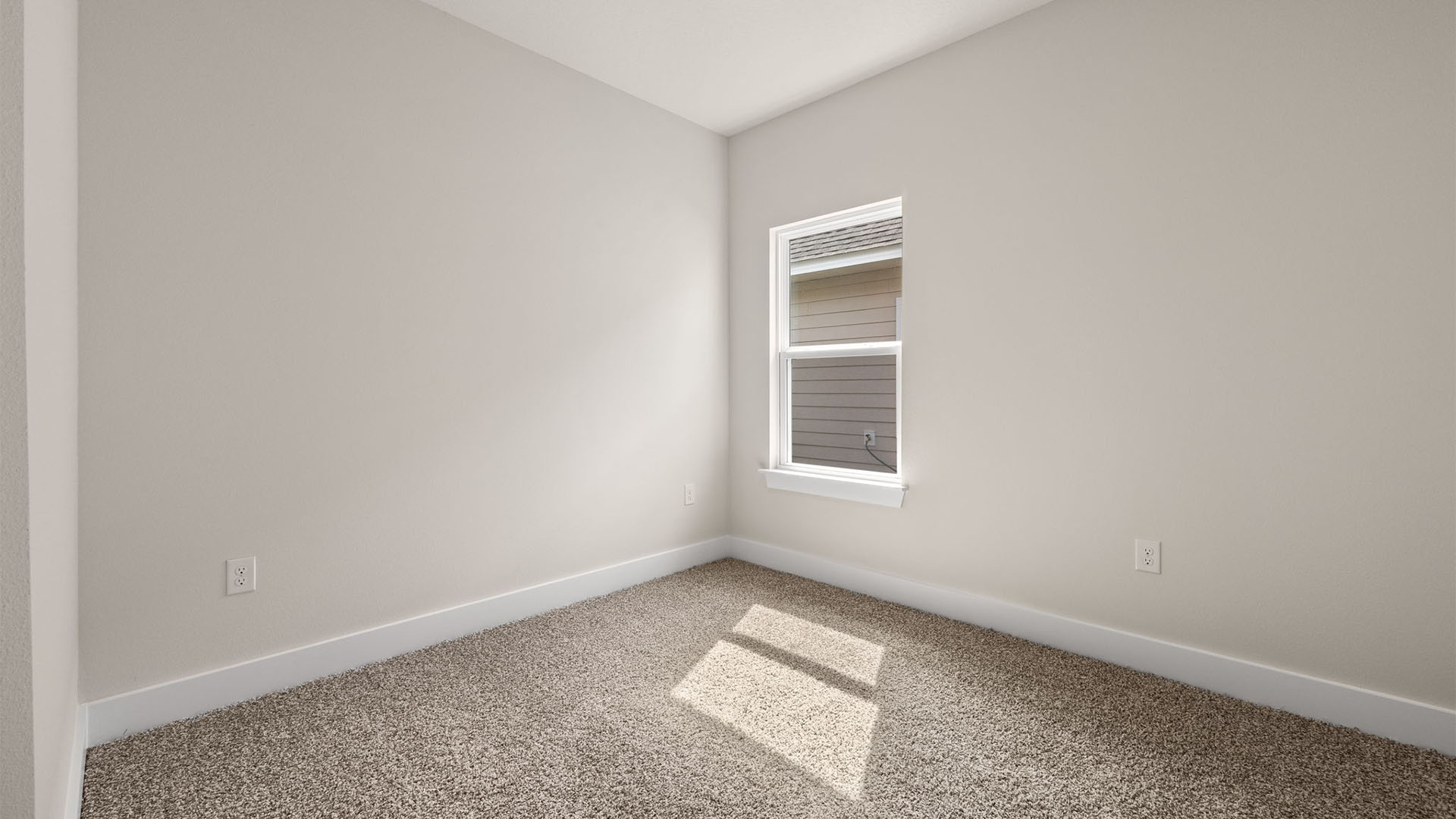 Bedroom with carpet flooring and window.