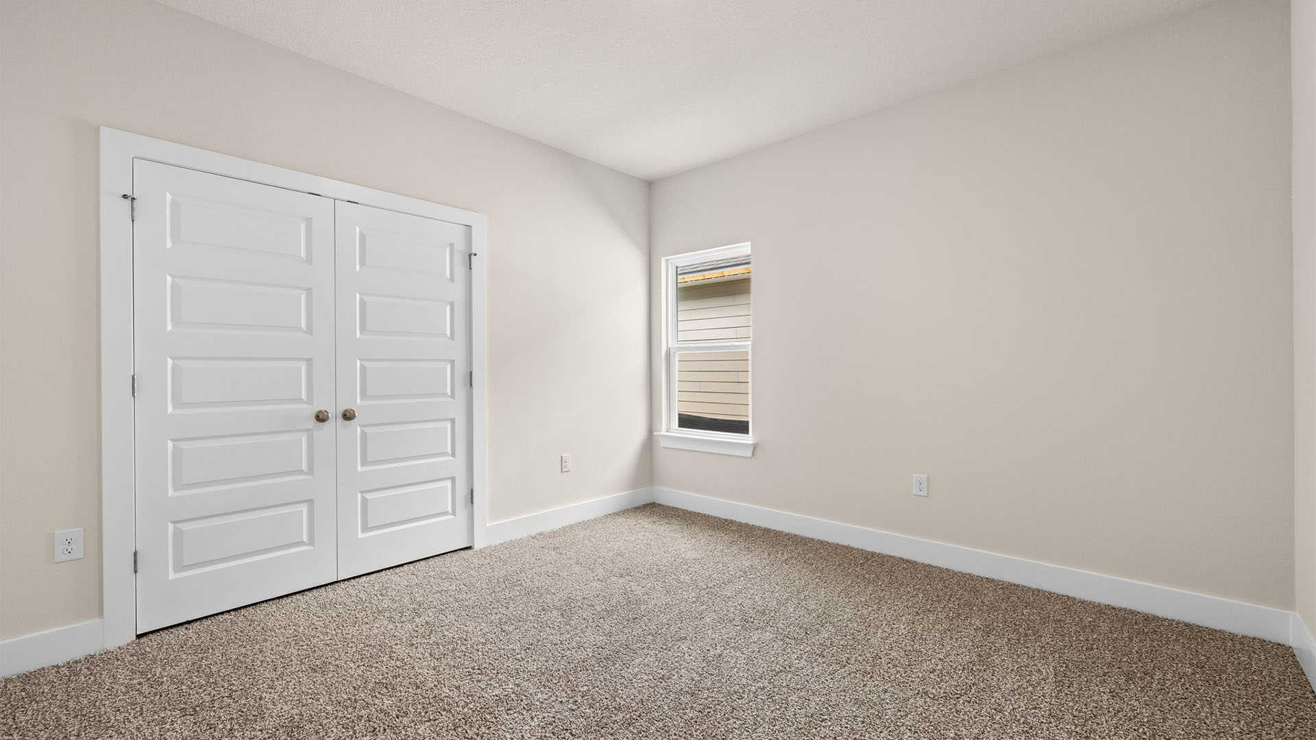 Bedroom with carpet flooring and window.