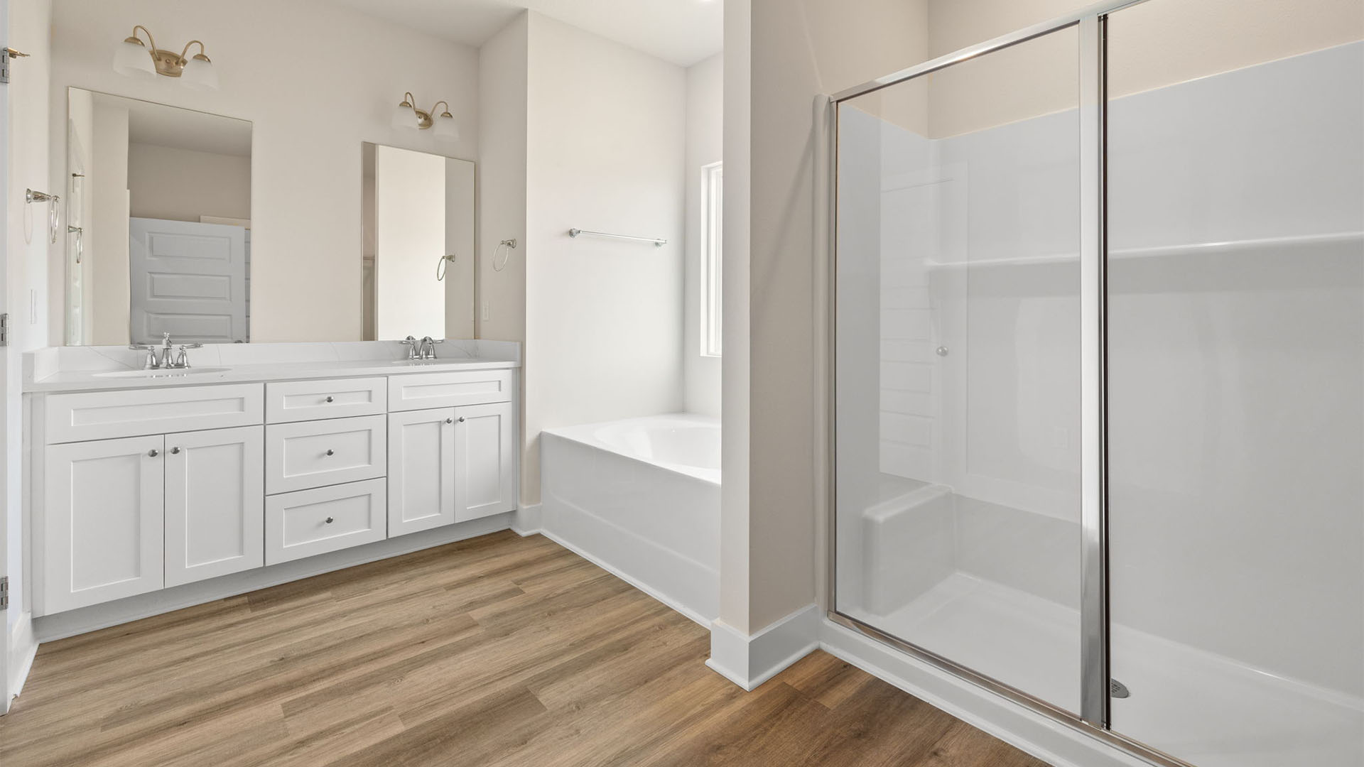 Primary bathroom with double vanity granite countertops and EVP flooring and white cabinets.