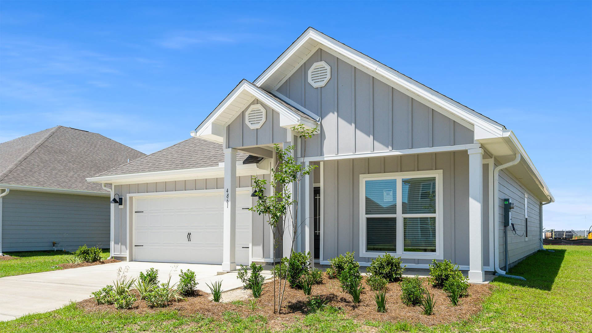 Rhett floor plan at Titus Park front of home with Hardie board siding and covered front porch and two-car garage.