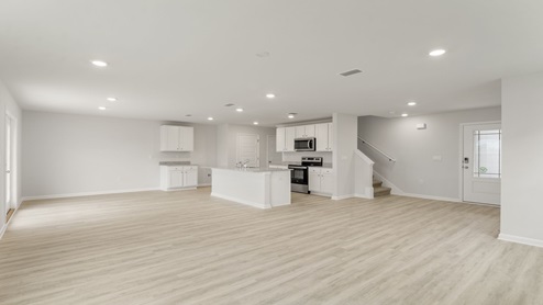 Open living room with EVP flooring and kitchen and dining area.