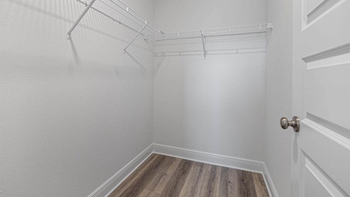 Walk in closet with EVP flooring and ventilated shelving.