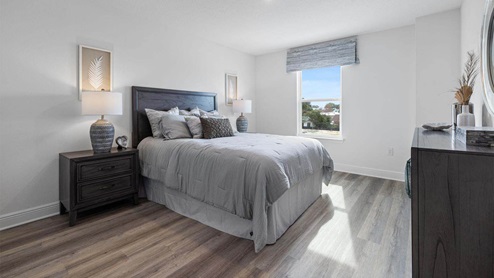 Bedroom with EVP flooring and window.