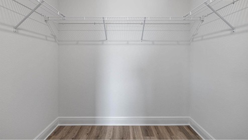 Walk in closet with EVP flooring and ventilated shelving.