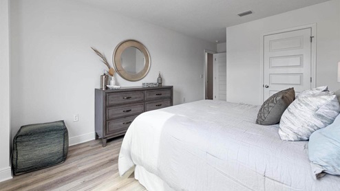 Bedroom with EVP flooring and closet.
