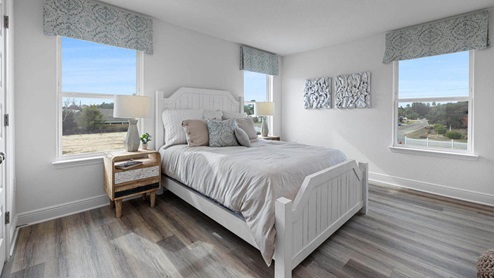 Bedroom with EVP flooring and windows.