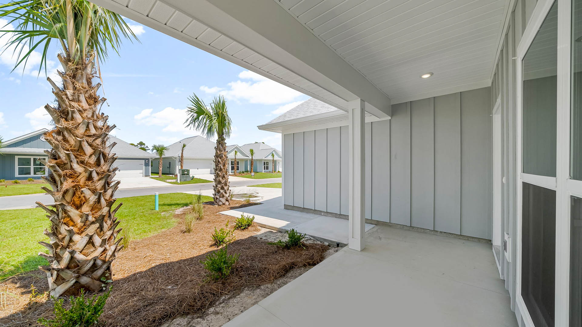 Front covered patio view with walkway and driveway.