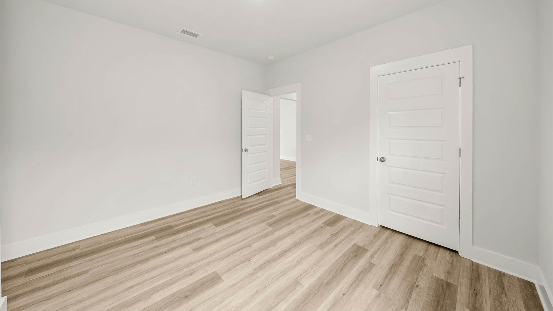 Bedroom with EVP flooring and closet.