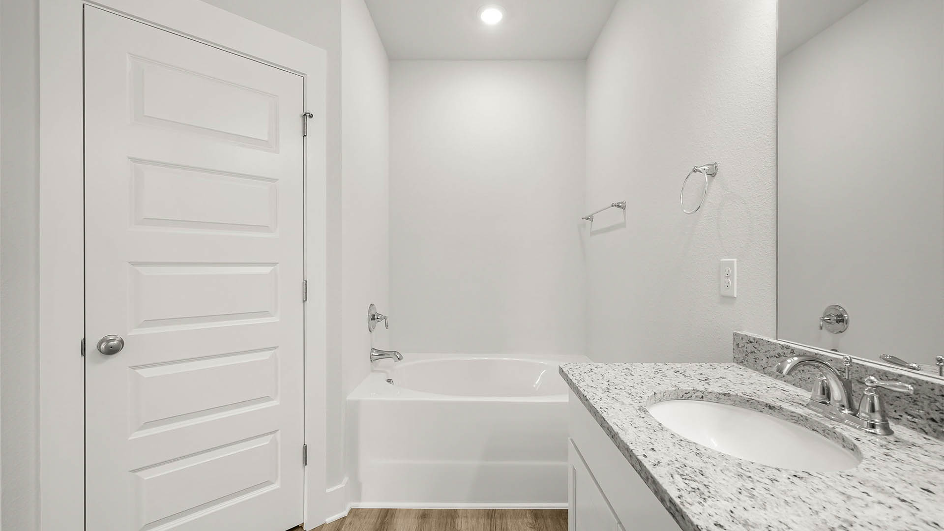 Primary bathroom with granite countertops and tub and closet.