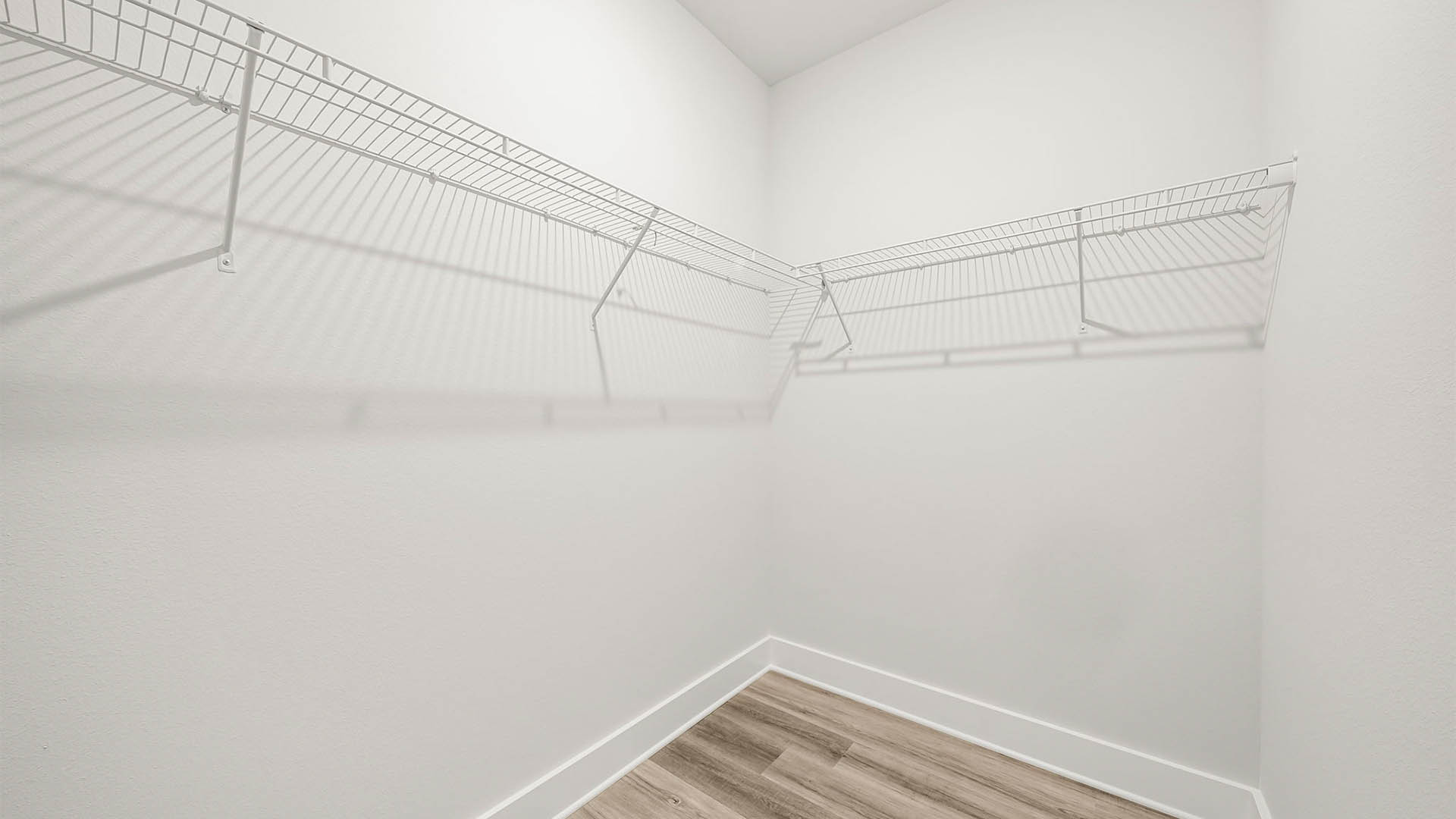 Primary bedroom closet with EVP flooring and ventilated shelving.