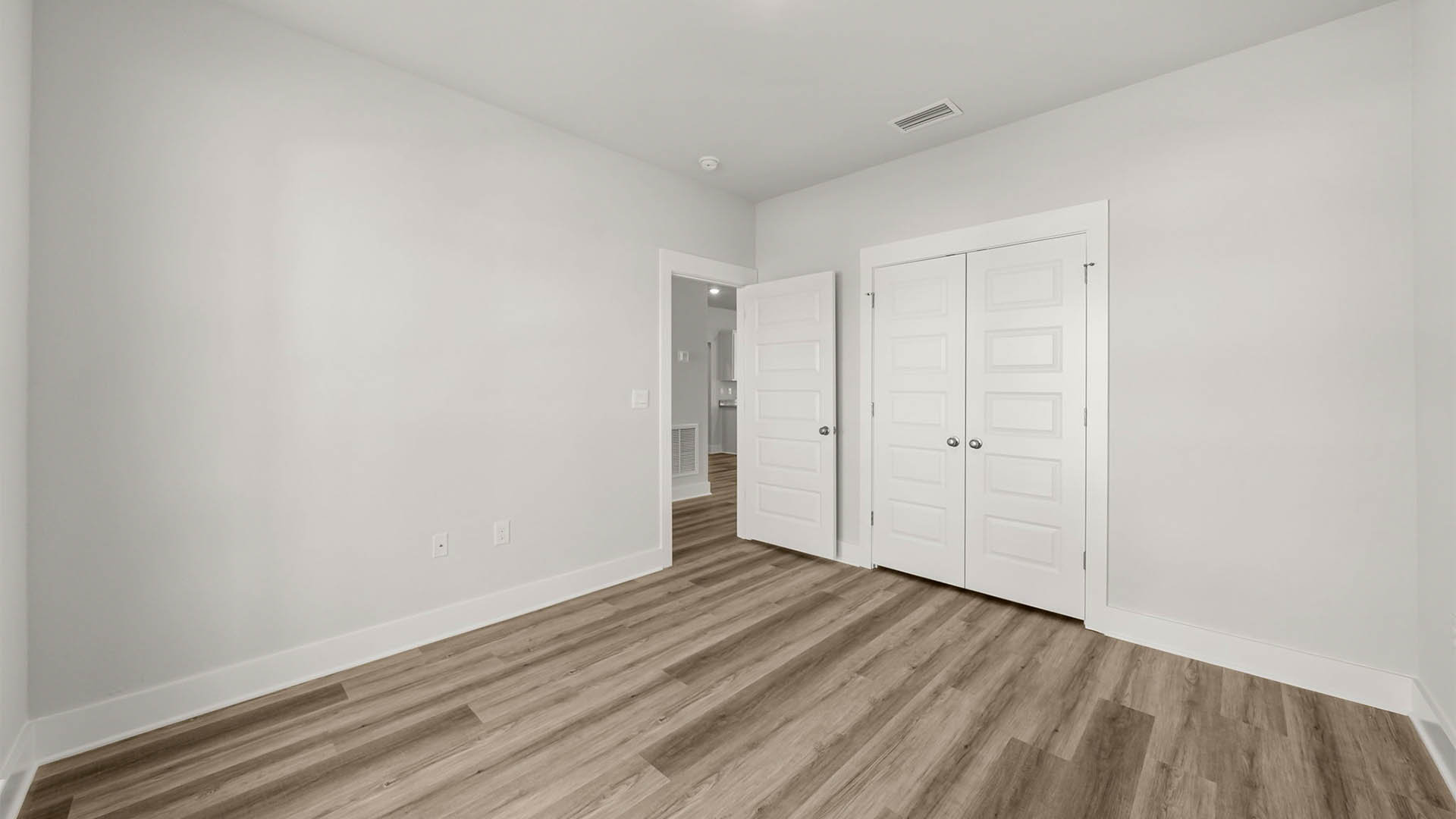 Bedroom with EVP flooring and closet.