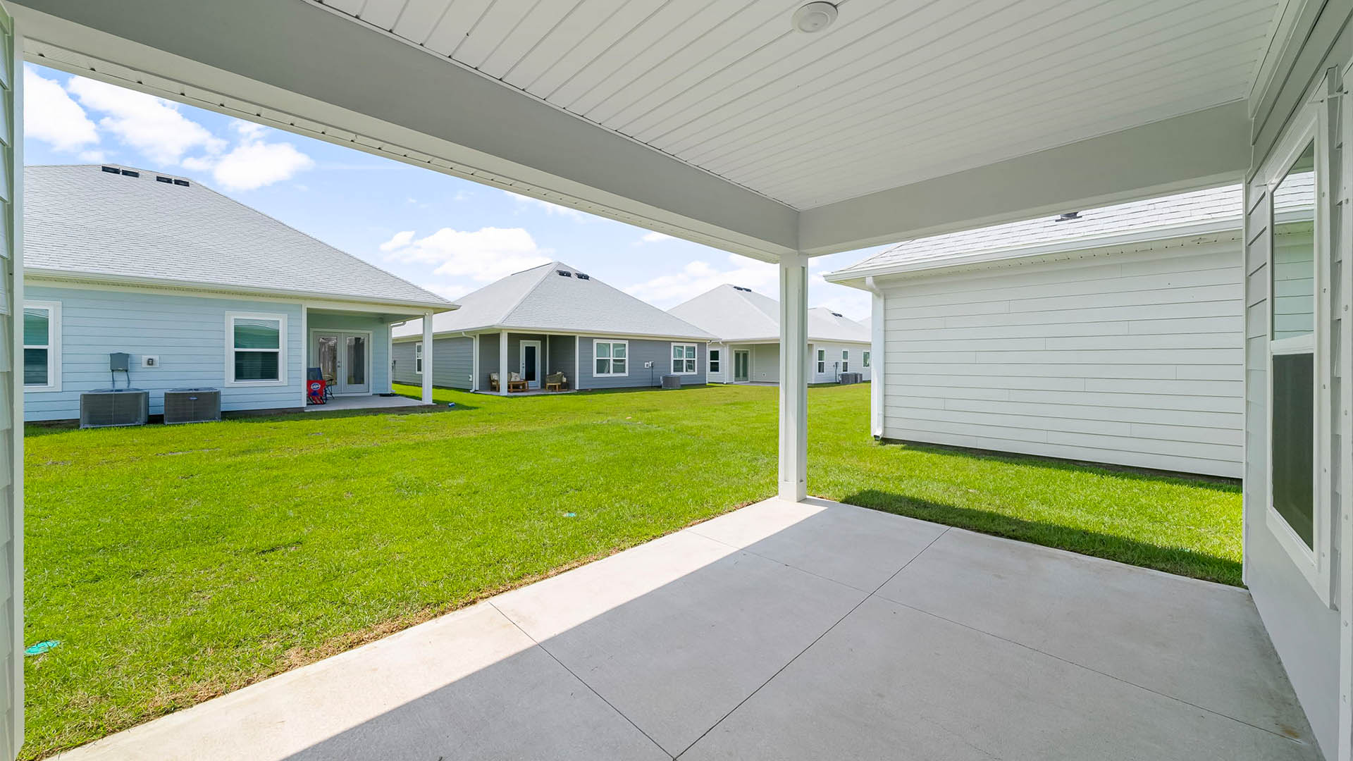 Covered rear patio and backyard view.