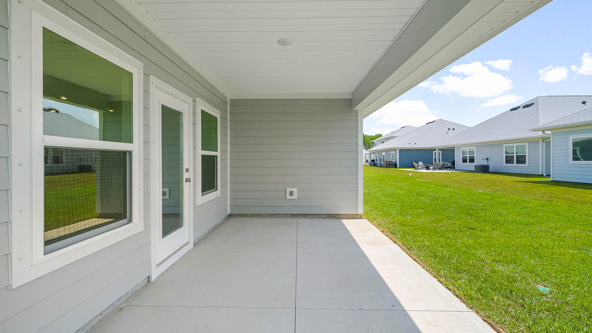 Covered rear patio and backyard view.