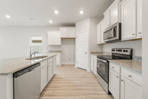 Main kitchen with EVP flooring and granite countertops and stainless-steel appliances.