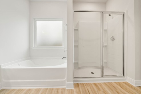 Separate tub and shower with glass door.