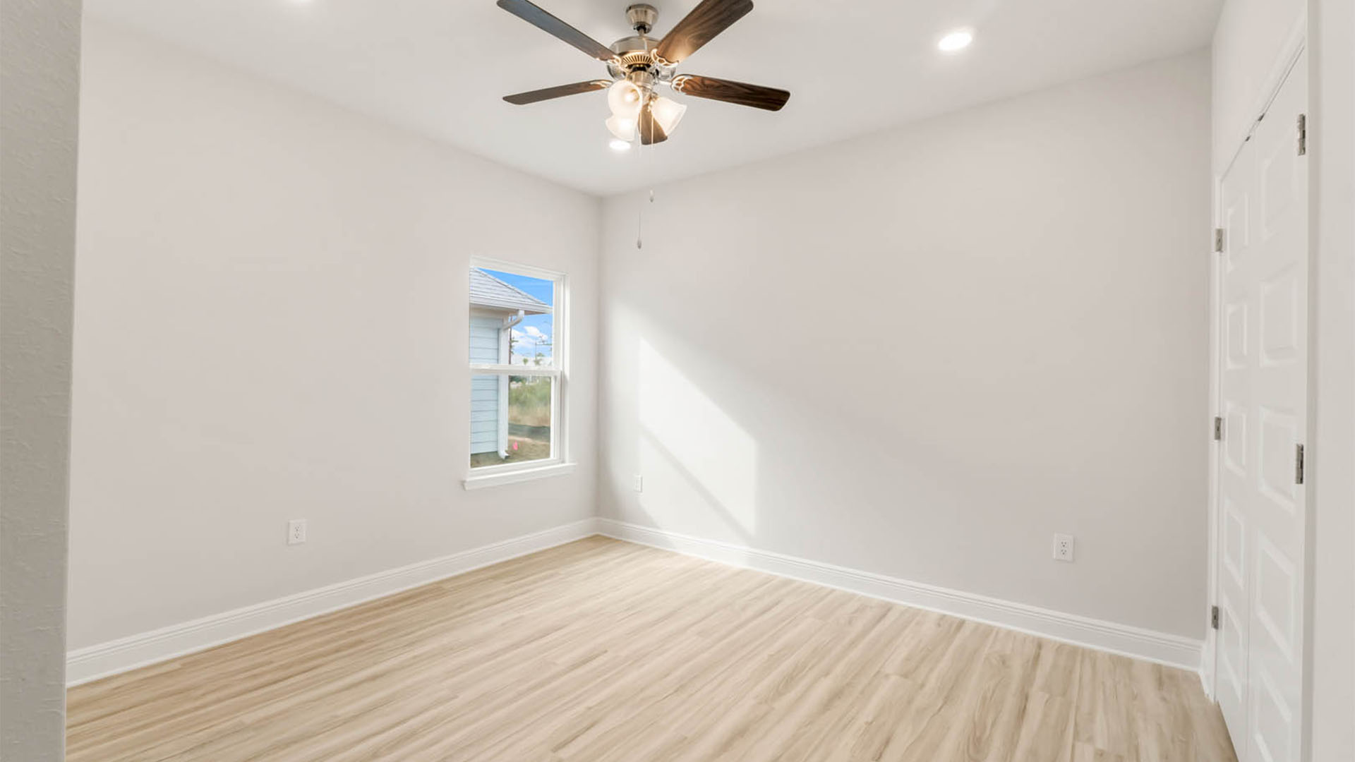 Bedroom with EVP flooring and window and ceiling fan.