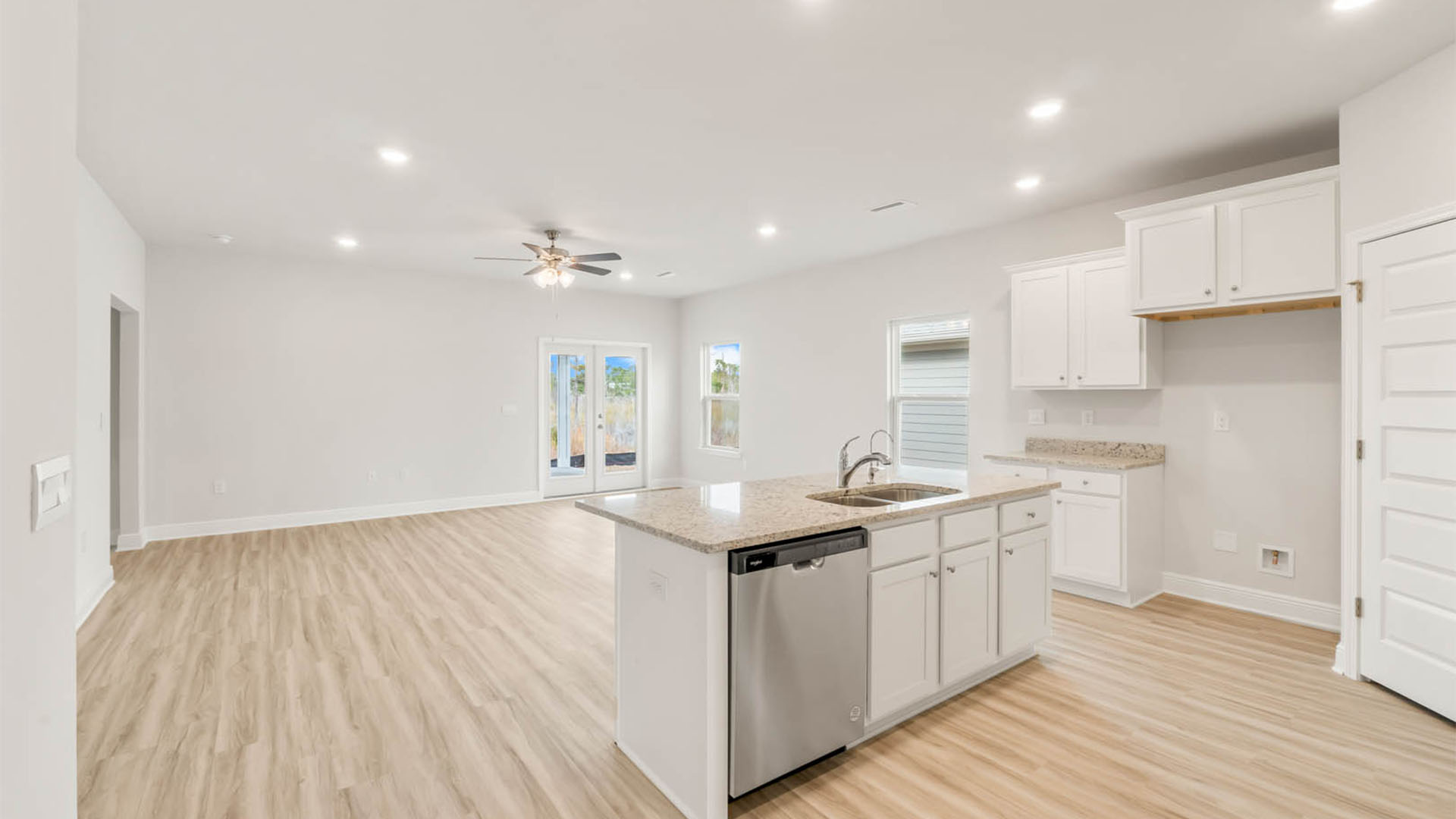 Main kitchen island with granite countertops and living room.