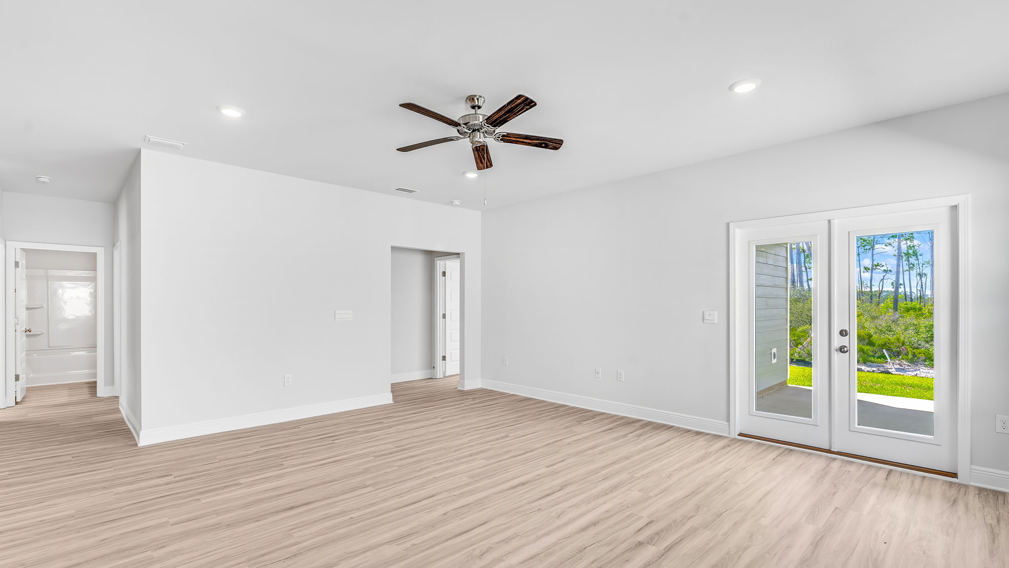 Living room with EVP flooring and ceiling fan and back door.
