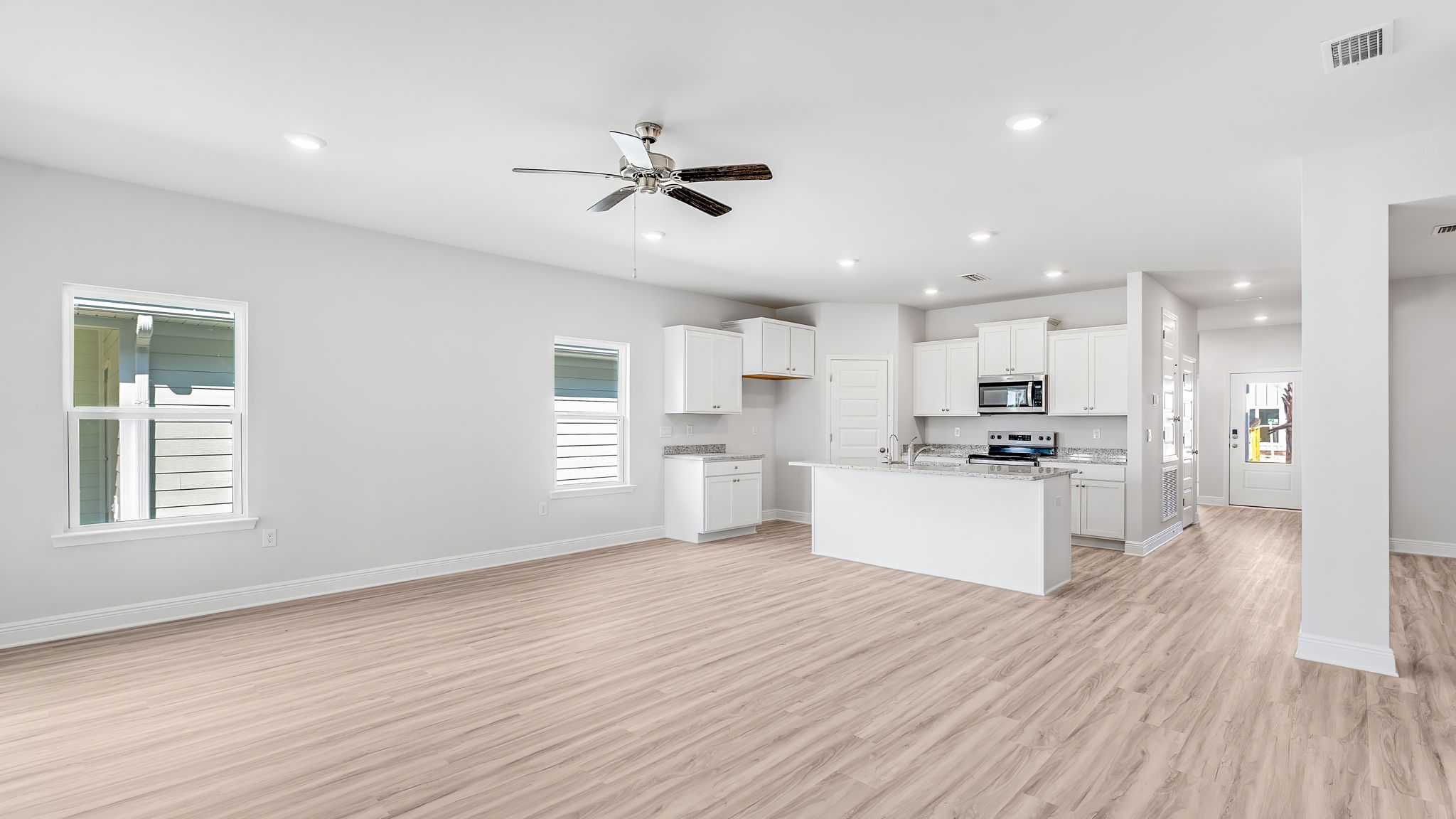 Living room with EVP flooring and ceiling fan and back door.