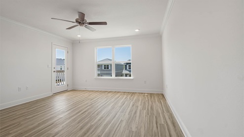 Primary bedroom with EVP flooring and balcony door and ceiling fan.