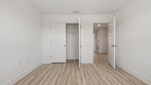 Bedroom with EVP flooring and closet.