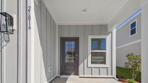 Covered front patio and front prairie style door.