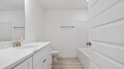 Bathroom with EVP flooring and single vanity quartz countertops and white cabinets.