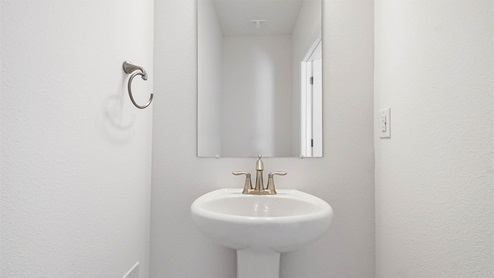 Half bathroom with sink and mirror.