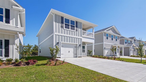 Monroe floor plan at WindMark Beach with Hardie siding and covered front porch and balcony and 1 car garage.