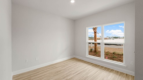 Bedroom with EVP flooring and two windows.