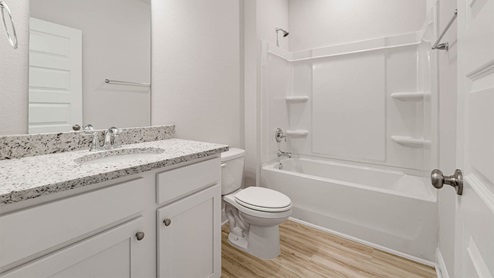 Bathroom with single vanity granite countertops and toilet and shower and tub combo with EVP flooring.