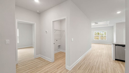 Hallway next to laundry room and bedroom and garage.