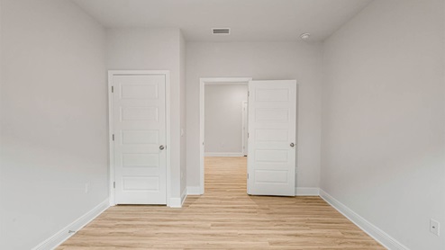 Bedroom with EVP flooring and closet.