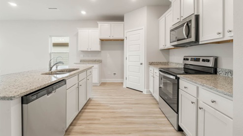 Main kitchen with EVP flooring and granite countertops and stainless-steel appliances.