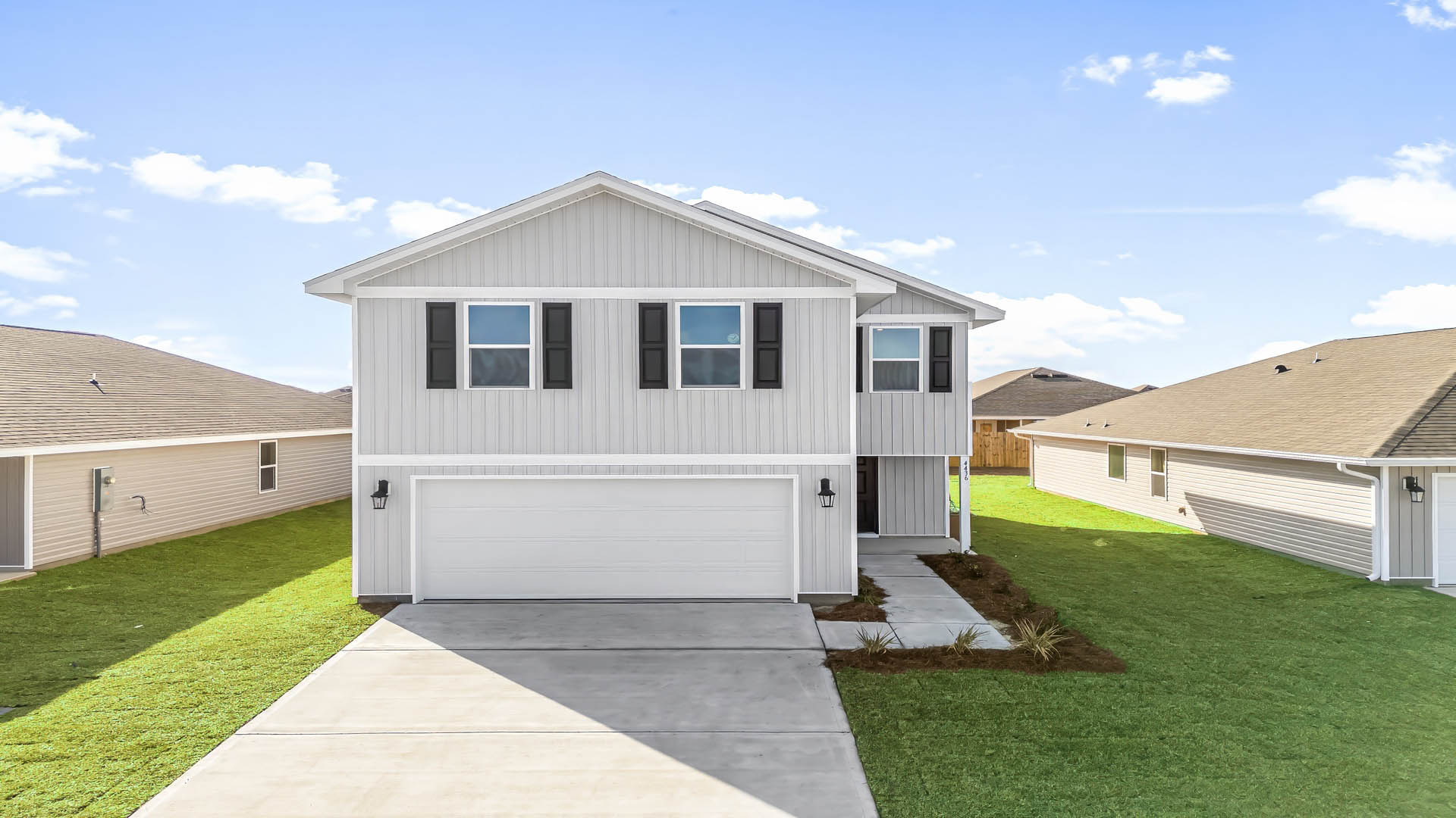 Aisle model at Titus Park front of home with vinyl siding and two-car garage.