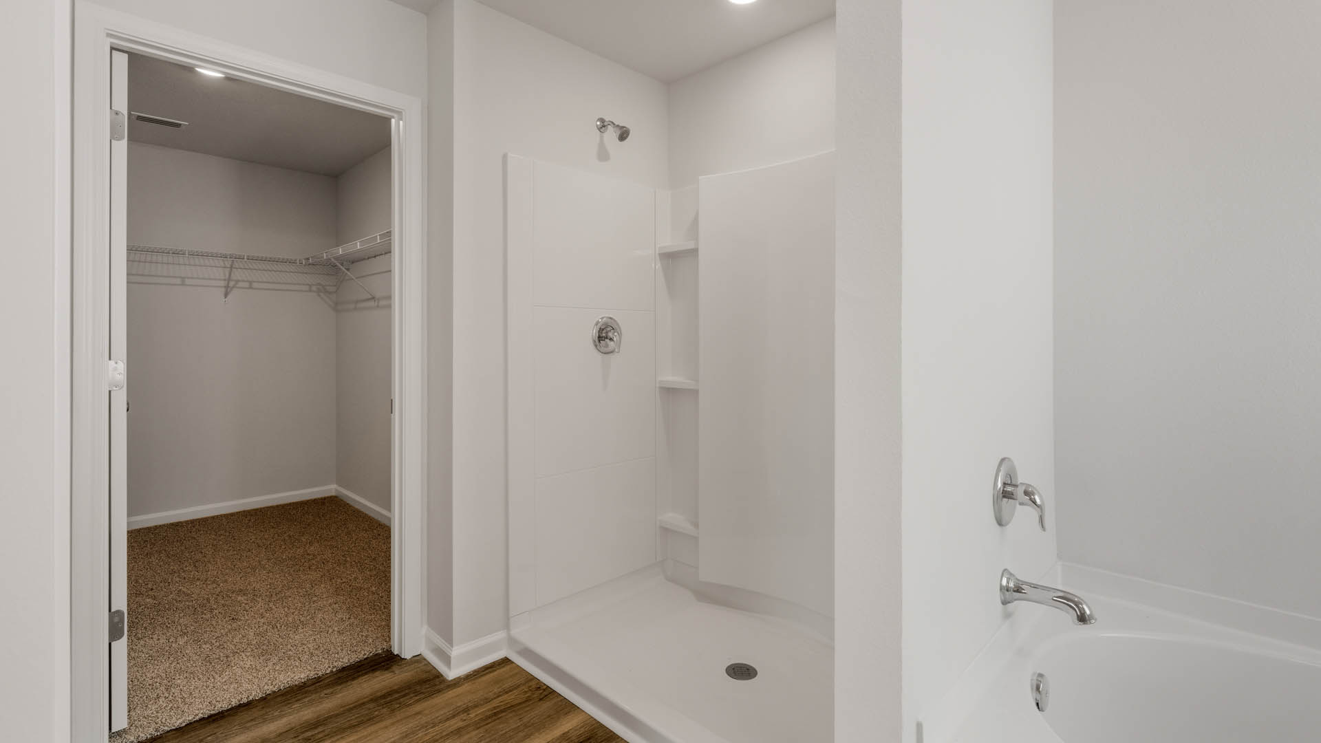 Primary bathroom with separate tub and shower and walk-in closet.