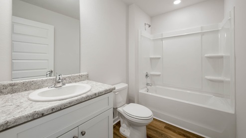 Bathroom with laminate countertops and single vanity and tub.