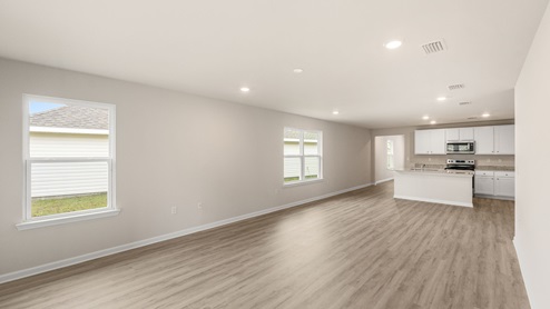 Open living room with EVP flooring and two windows.